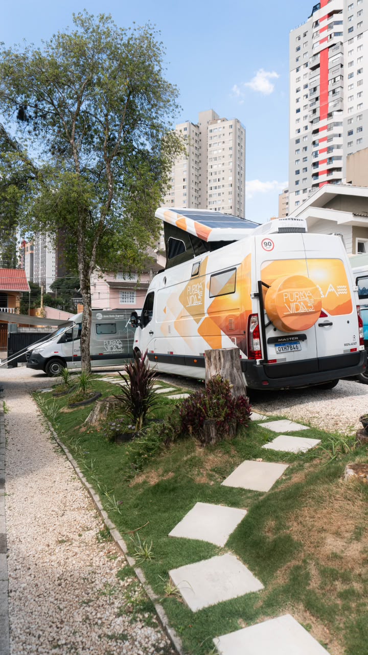 Traseira do motorhome Pérola, van branca com teto elevatório e painéis solares