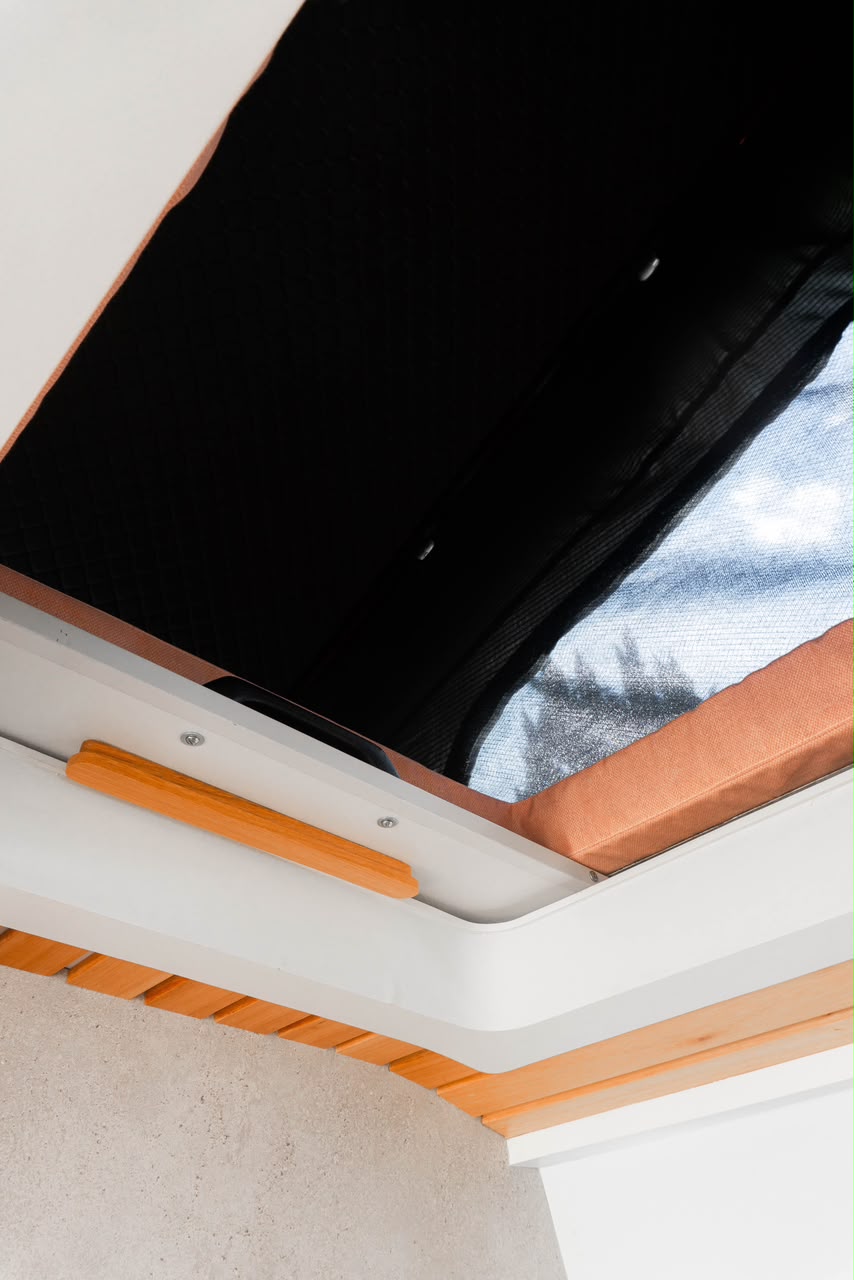 Detalhe do teto elevatório do Pérola, com colchão extra e acabamento em ripas de madeira